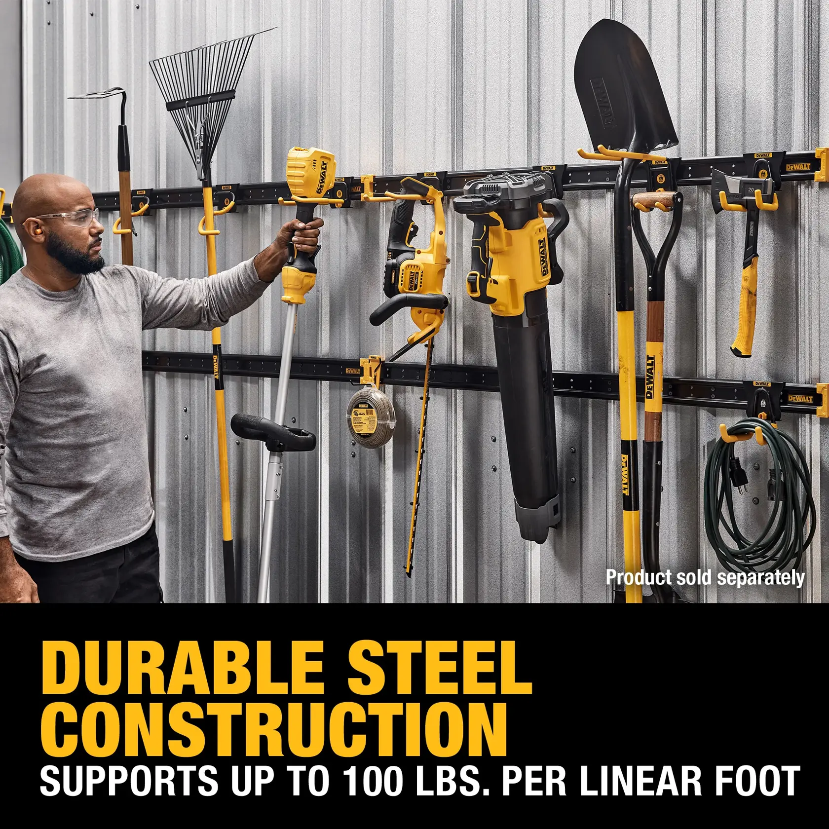 A person is organizing outdoor tools such as a shovel, rake, trimmer, leaf blower, and power tools on a DEWALT steel wall rack system attached to a metal shed wall. The system advertises durable steel construction and supports up to 100 lbs. per linear foot. Tools and accessories are sold separately.