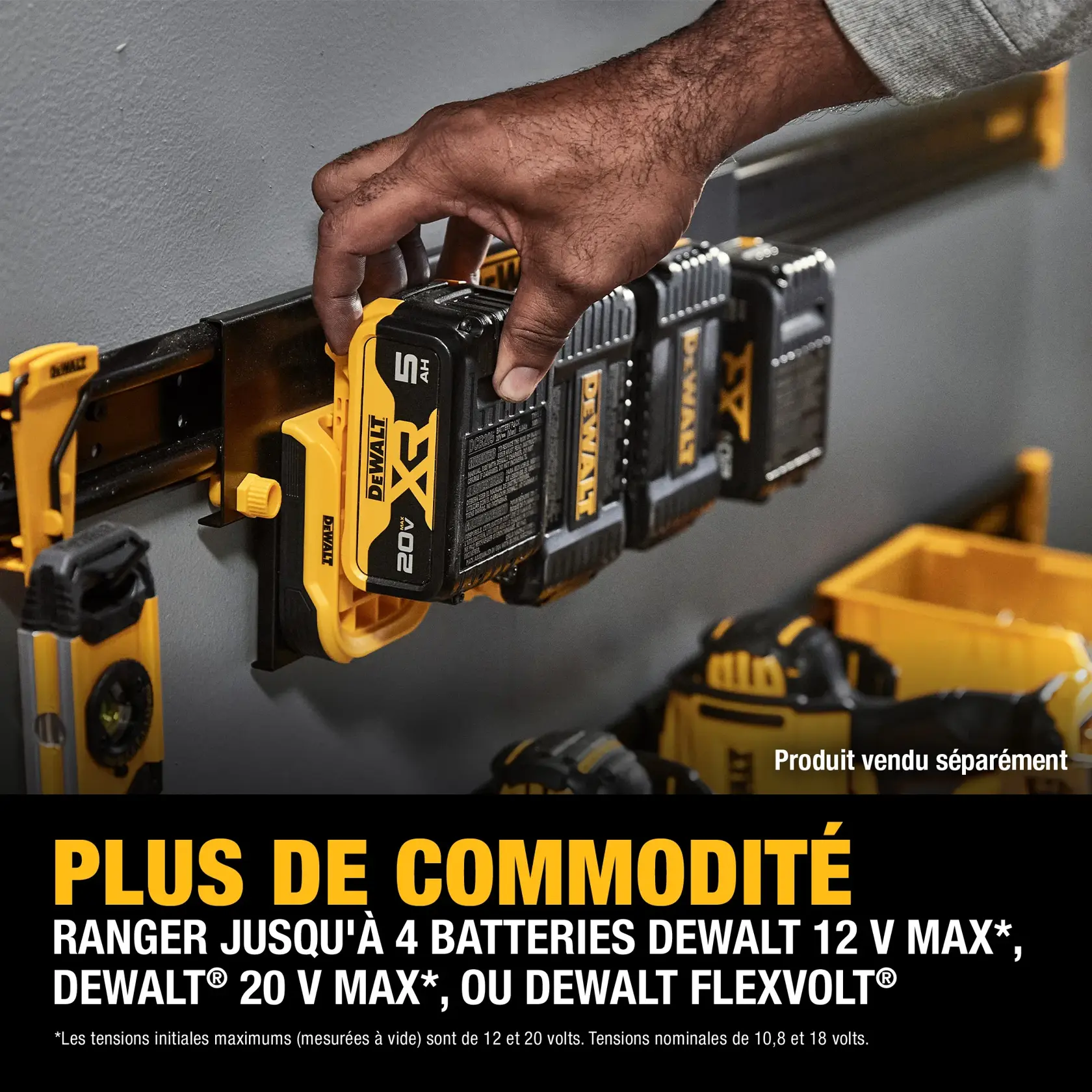 A DEWALT battery storage rack mounted on a wall holds up to four DEWALT 12V MAX, 20V MAX, or FLEXVOLT batteries. A hand is placing a battery into the rack. Other DEWALT tools and accessories are visible nearby. The text emphasizes added convenience for battery storage.