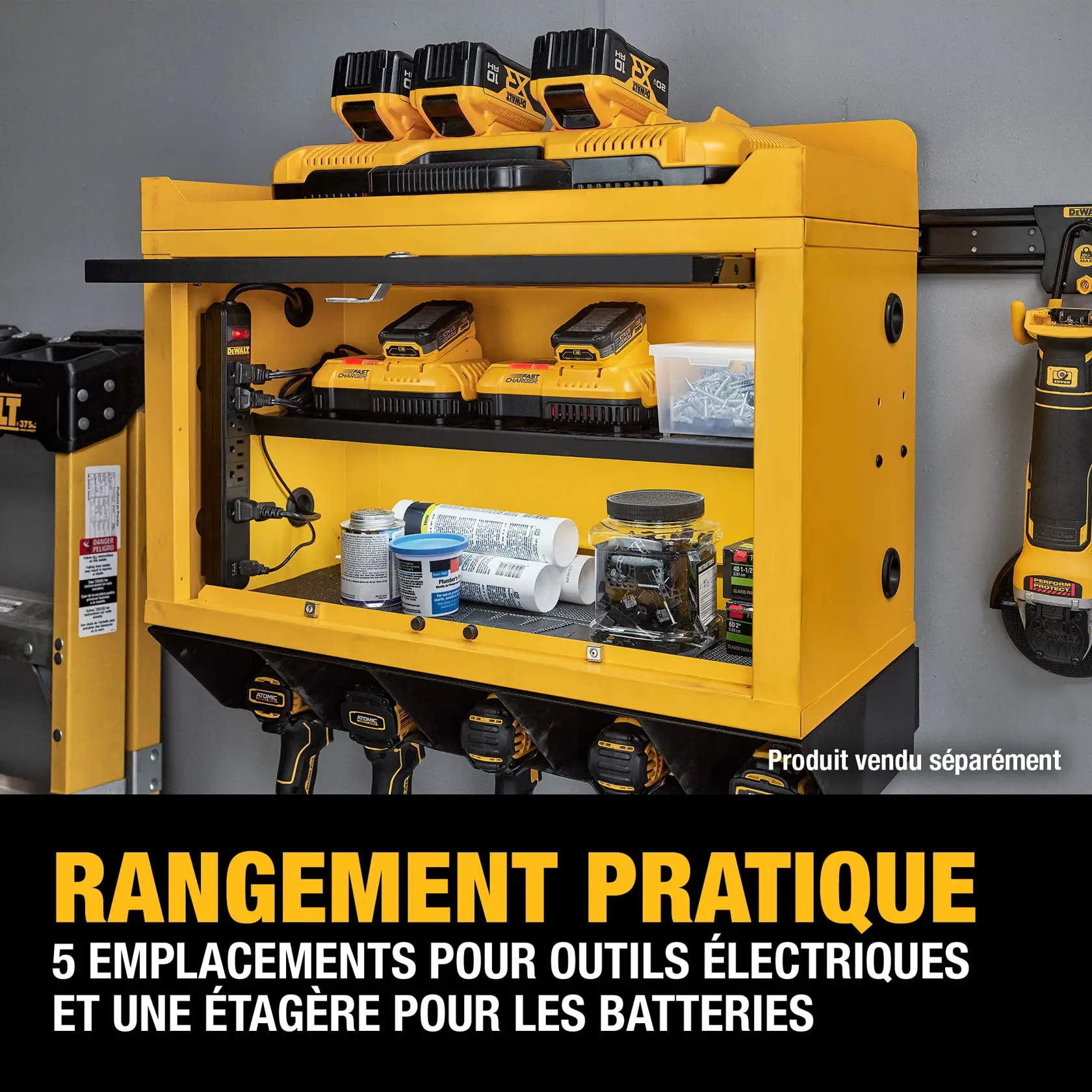 A yellow DEWALT wall-mounted storage cabinet with five slots holding power tools, a top shelf with four batteries charging, and additional shelves storing screws, containers, and tools. Large text at the bottom reads: 'CONVENIENT STORAGE - 5 POWER TOOL SLOTS AND A BATTERY SHELF.' The cabinet is organized and labeled 'Product sold separately.'