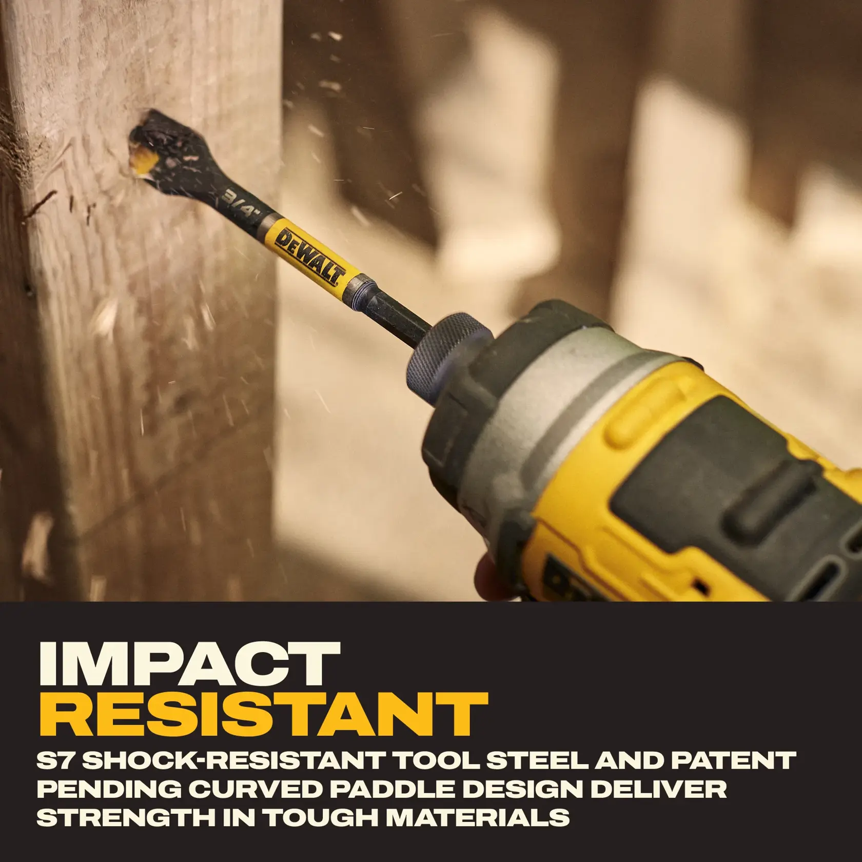 A close-up of a yellow and black DEWALT power drill being used to drill into a wooden beam with a paddle bit. Text on the image highlights impact resistance, S7 shock-resistant tool steel, and a patent pending curved paddle design for strength in tough materials.