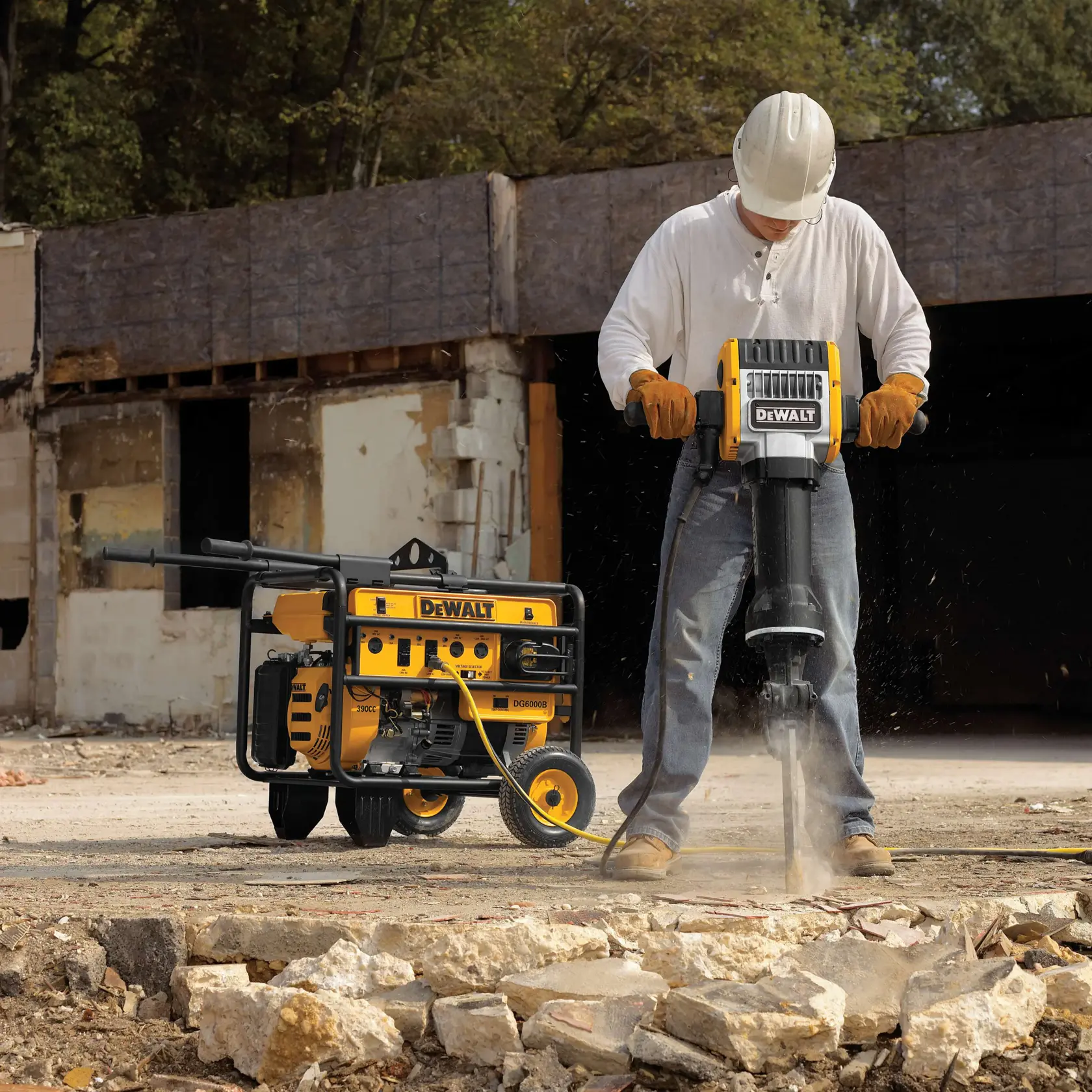 A construction worker wearing a hard hat, gloves, and work boots operates a DEWALT jackhammer breaking concrete, with a DEWALT generator in the background at an outdoor demolition site.