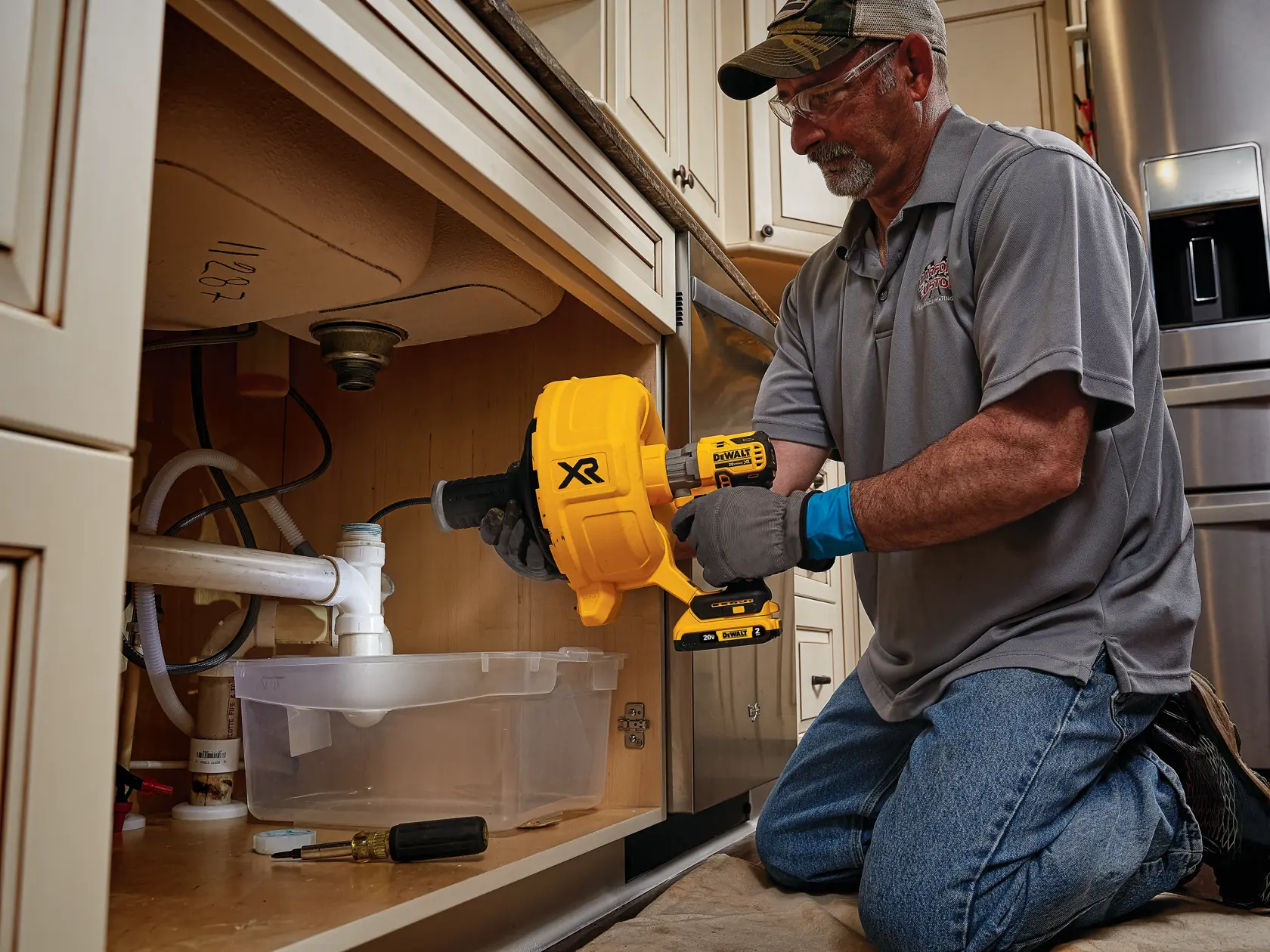 Image of a DEWALT DCD200D1 cordless drain snake tool. The tool is yellow and black with labeled features including a fixed shroud, brushless motor, easy to remove drum, easy release mechanism, black oxide coated cable with high-performance inner core, and pivoting 3-mode LED lights.