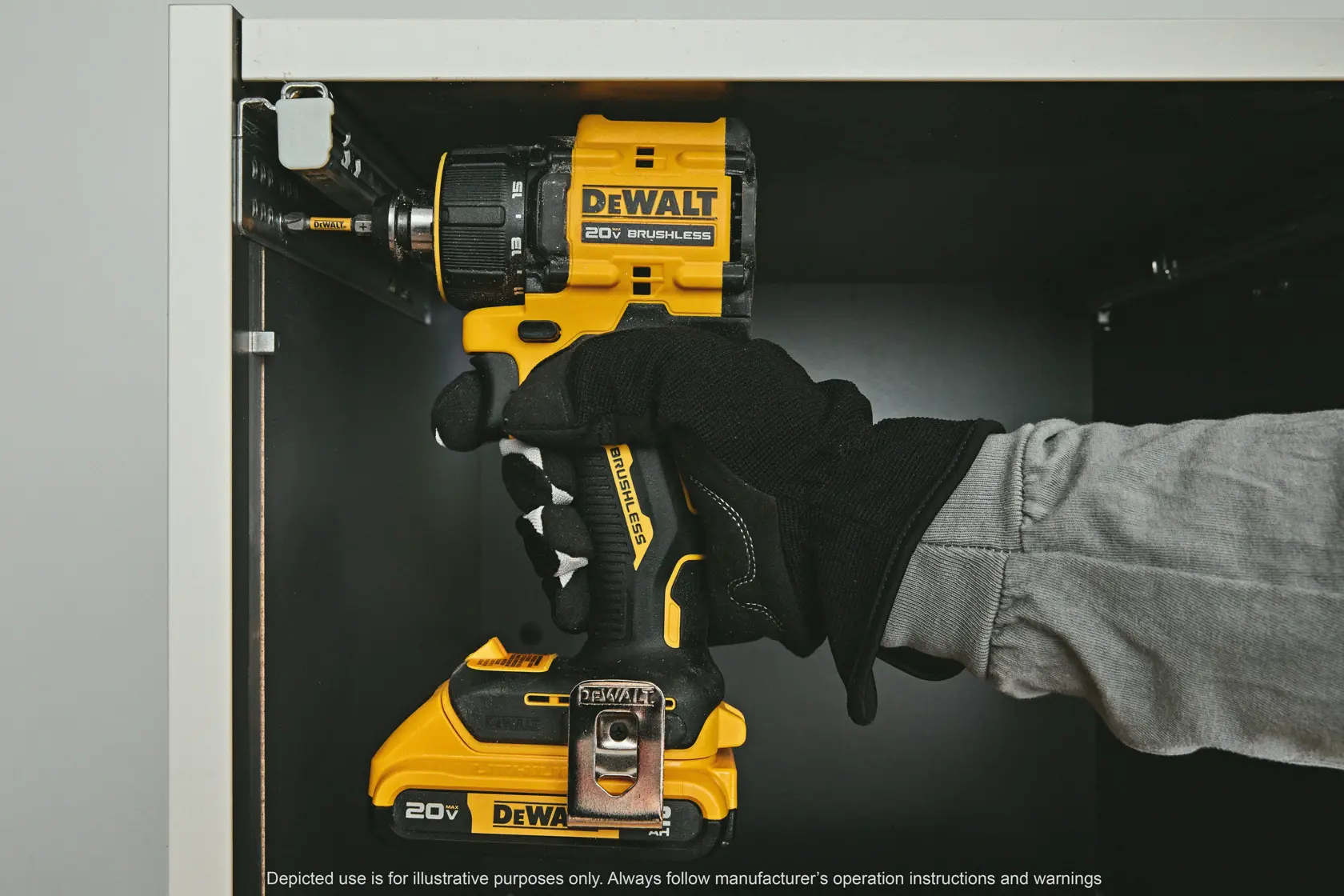 A gloved hand using a DEWALT 20V brushless cordless drill to screw into a metal bracket inside a cabinet.