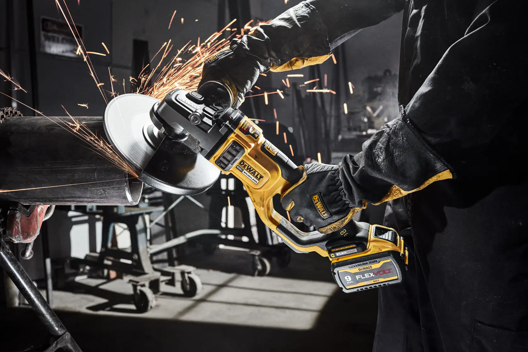 A person using a DEWALT cordless angle grinder to cut metal, with sparks flying in a workshop setting.