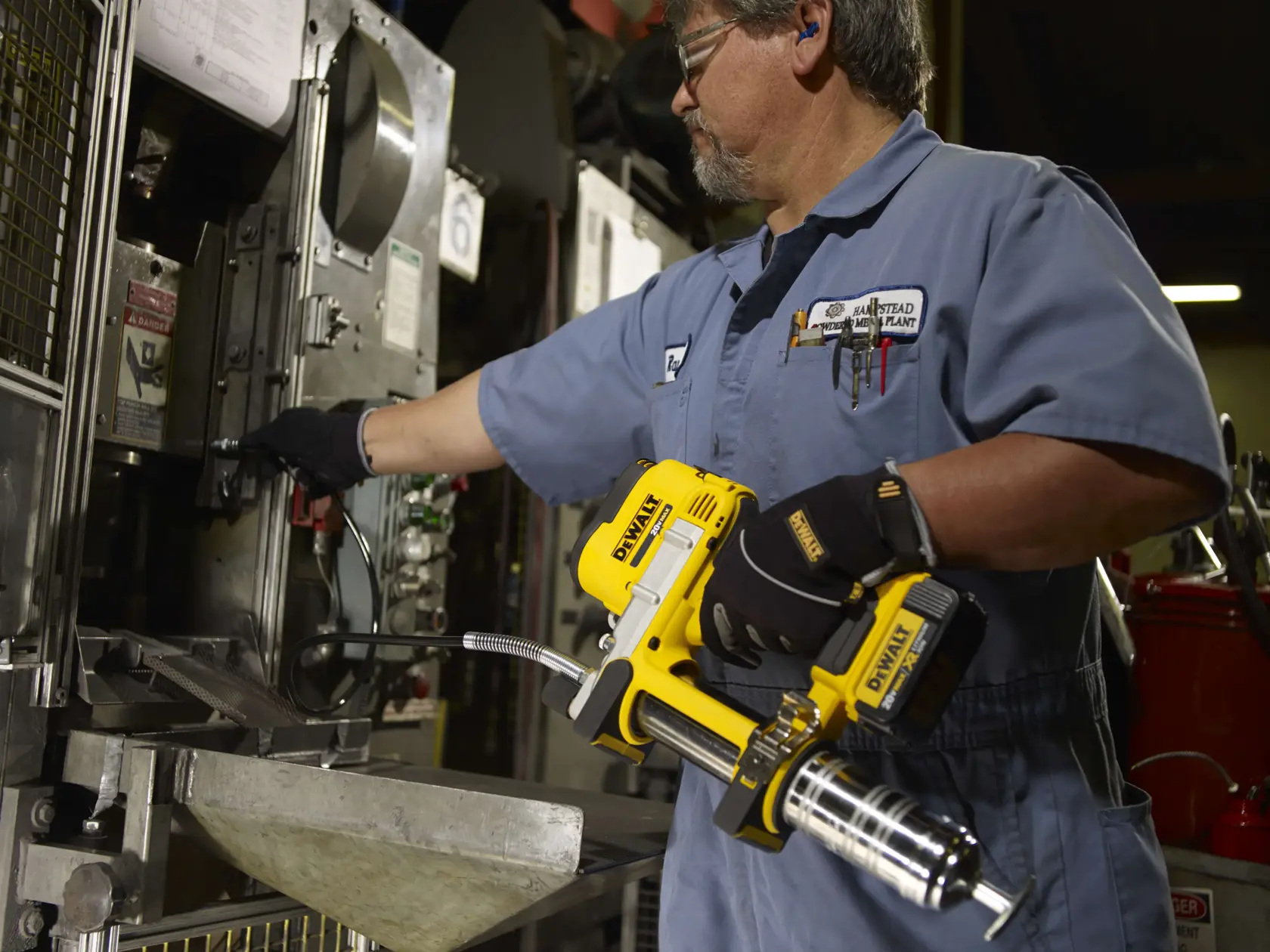 Grease gun being used by a person