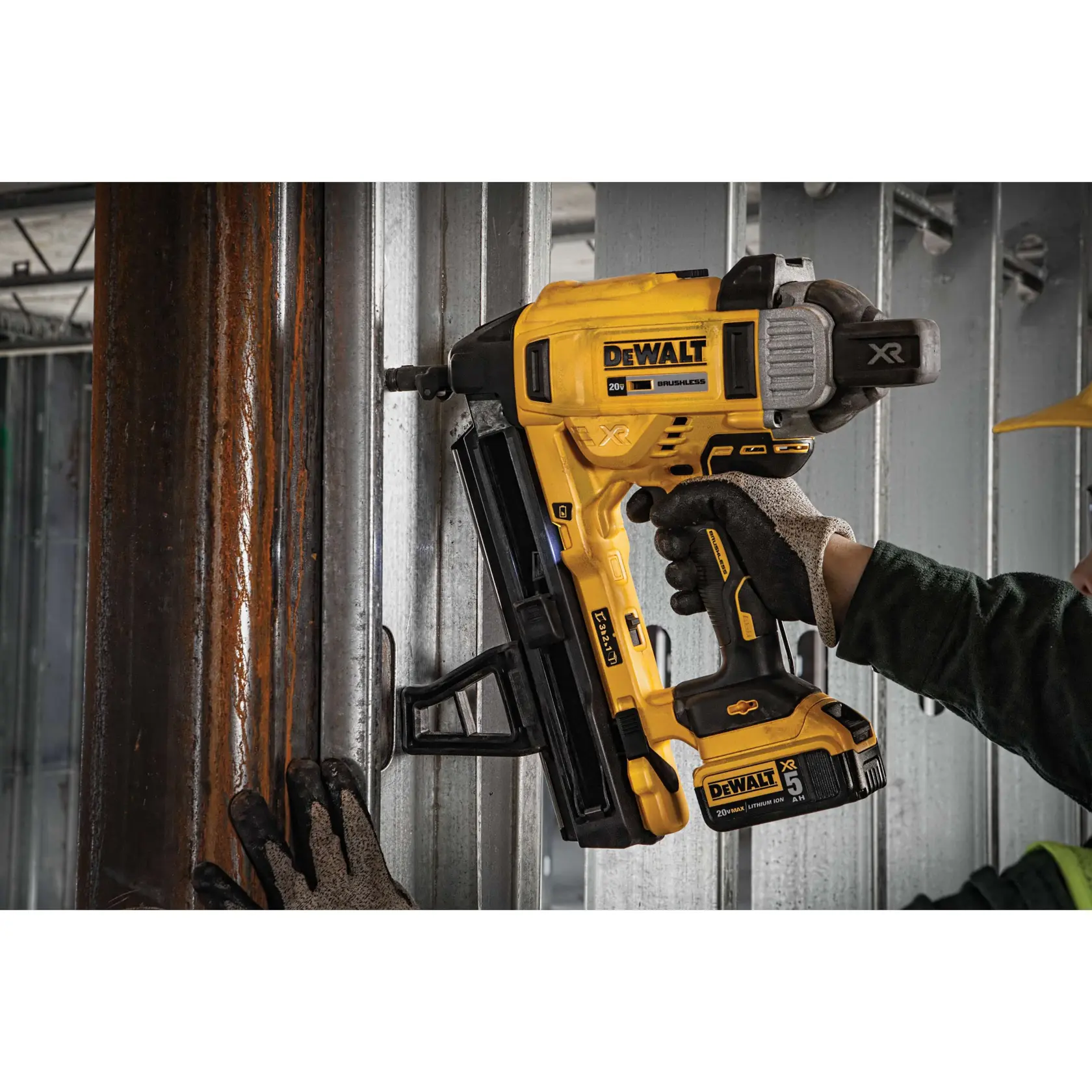 A DEWALT DCN890P2 20V cordless nailer being used by a person wearing work gloves to fasten metal framing in a construction setting.