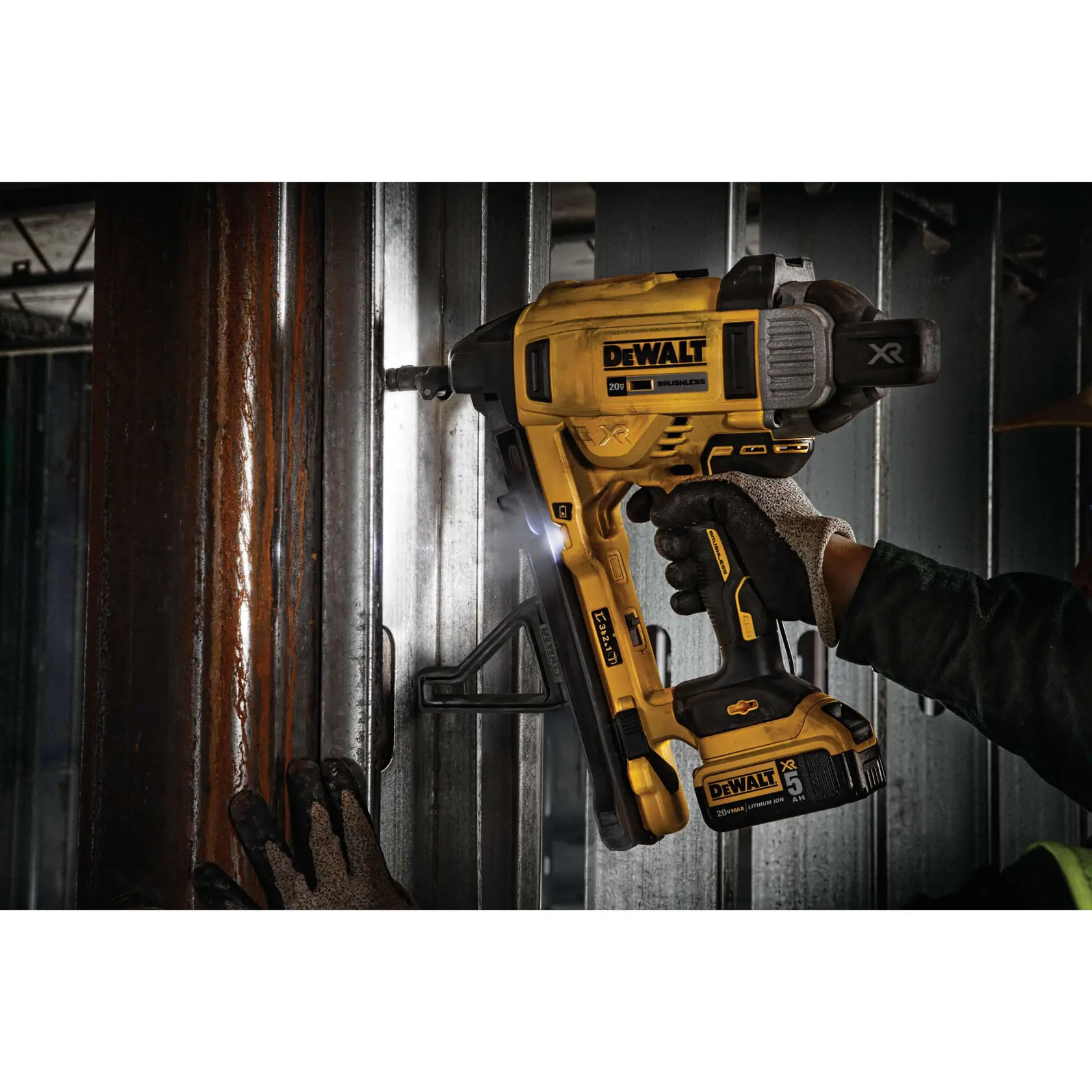 A DEWALT DCN891P2 cordless tool being used by a gloved worker to fasten metal components on a construction site. The tool is yellow and black, branded DEWALT, and features a lithium-ion battery.
