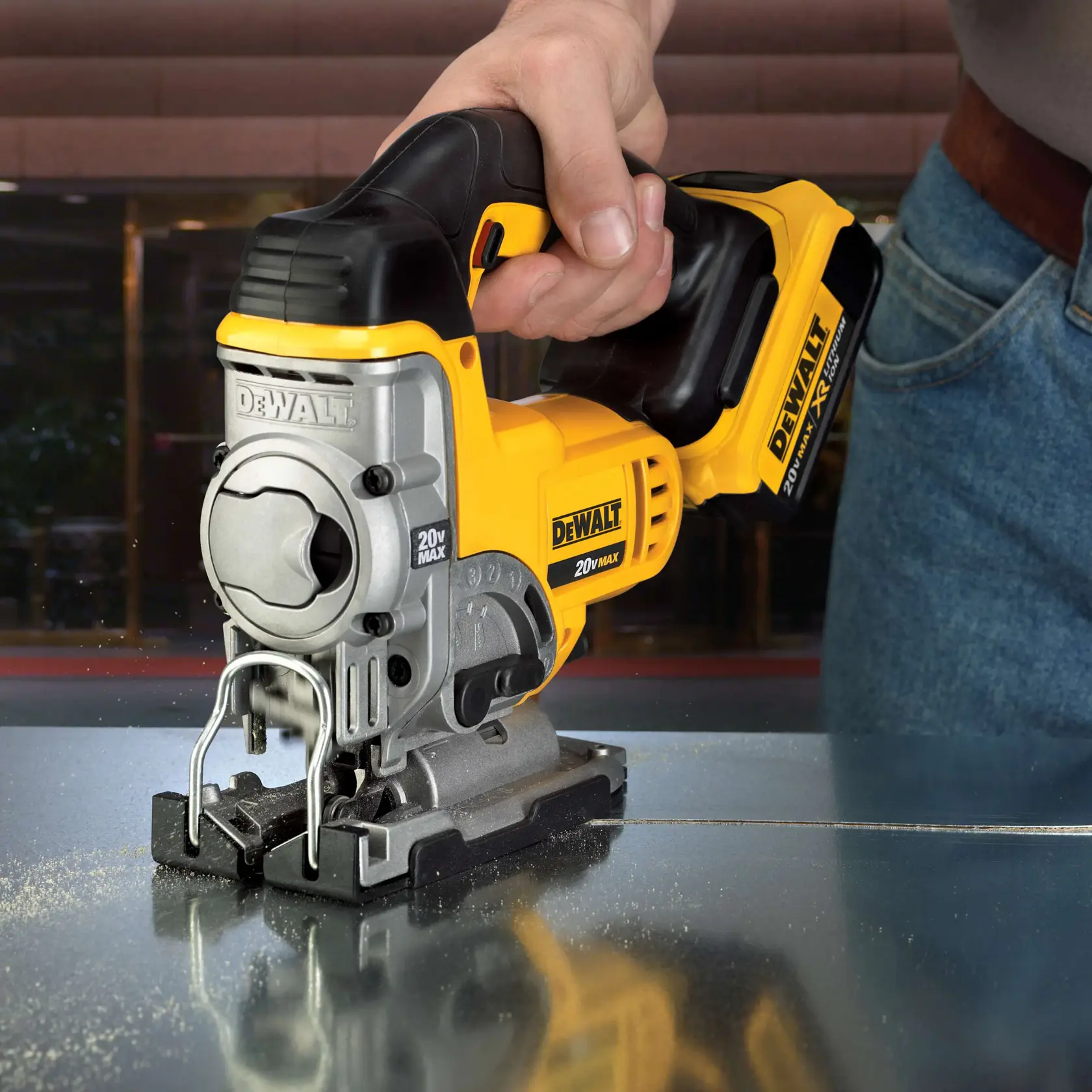 A close-up of a person using a DEWALT DCS331M1 20V Max cordless jigsaw to cut through a sheet of metal.