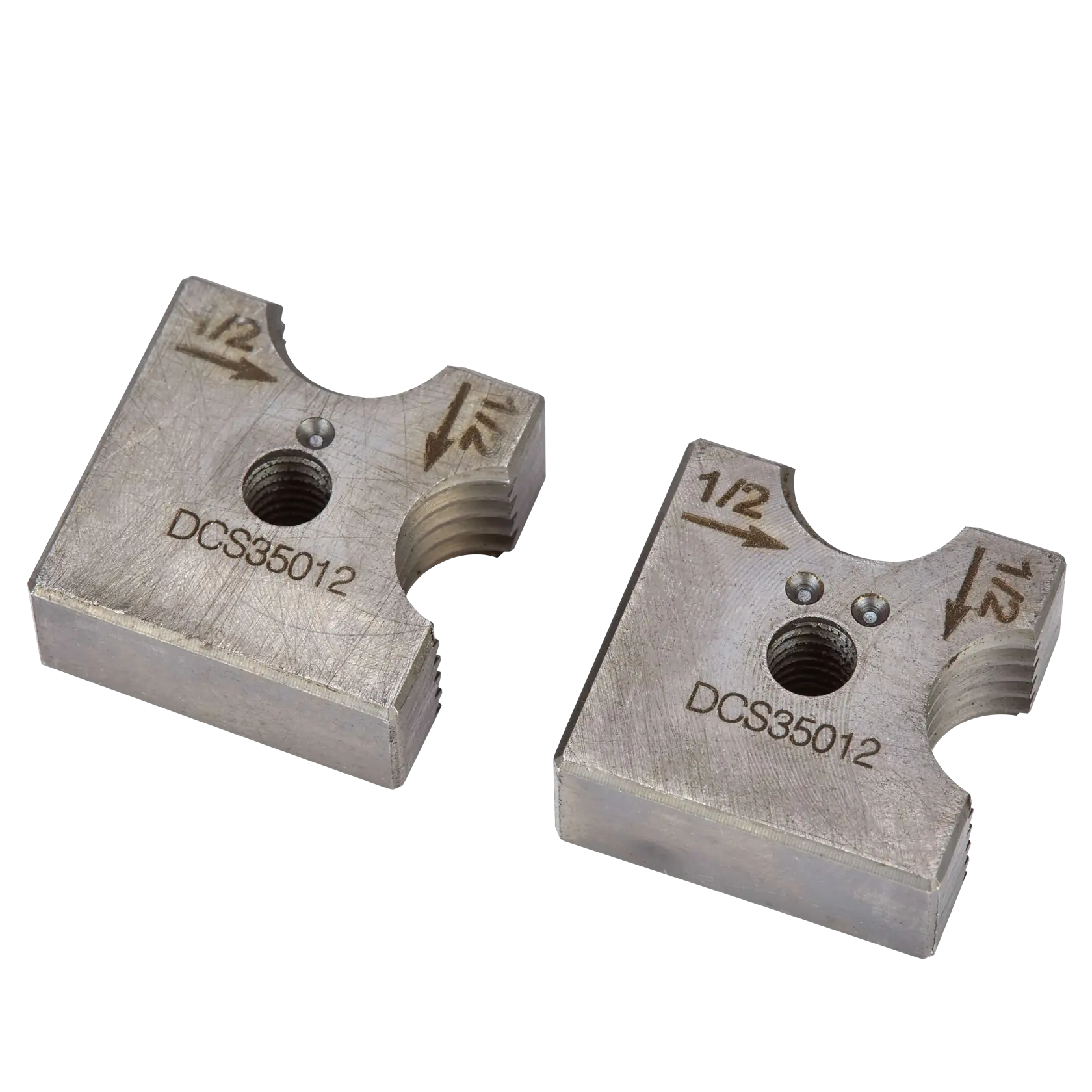 A pair of DEWALT DCS35012 metal dies for cutting or shaping, each marked with '1/2' and arrows, with a threaded hole in the center. They have a square shape with rounded cutouts.