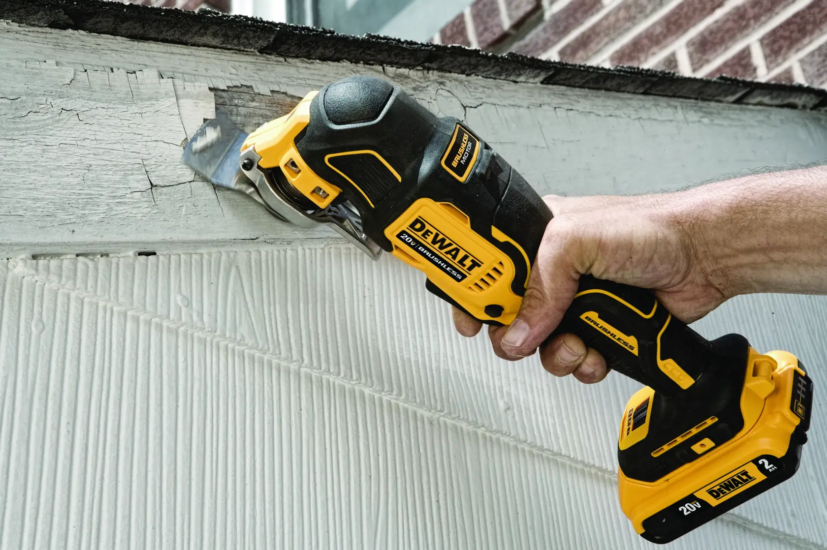 A hand using a DEWALT 20V brushless oscillating tool to cut or remove a bolt near the base of a white fixture, with the text 'Extended Runtime with Brushless Motor' displayed below.