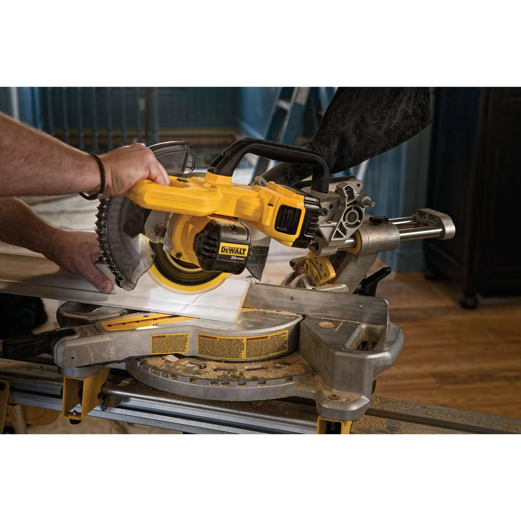 Person holding a DEWALT miter saw, emphasizing its compact and lightweight design for easy transport.