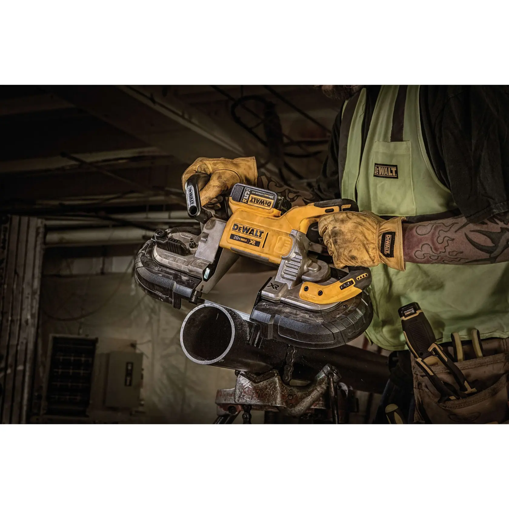 A DEWALT cordless portable band saw is hanging by its hook from a metal pipe stand in a workshop environment. Text on the image states, 'Hang hook prevents accidental damage.'
