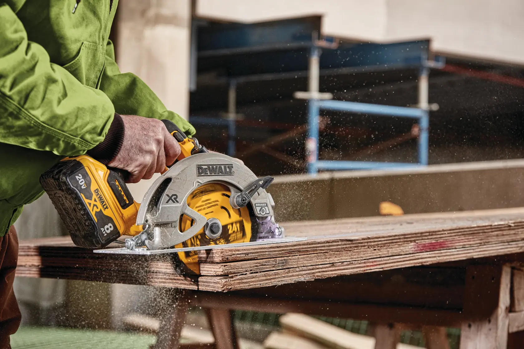 Une personne utilise une scie circulaire sans fil DEWALT pour couper une pile de planches en bois sur un chantier de construction.