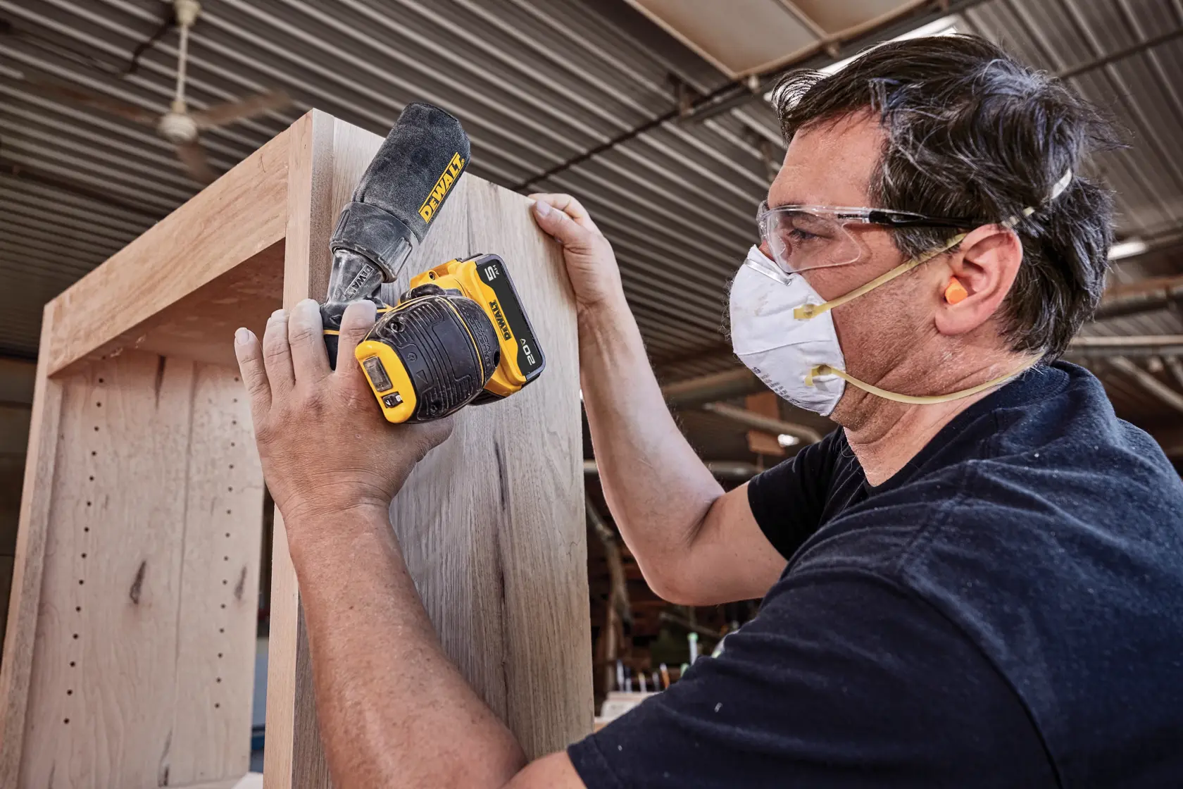 DEWALT cordless sander with brushless motor being used to sand a wooden plank.