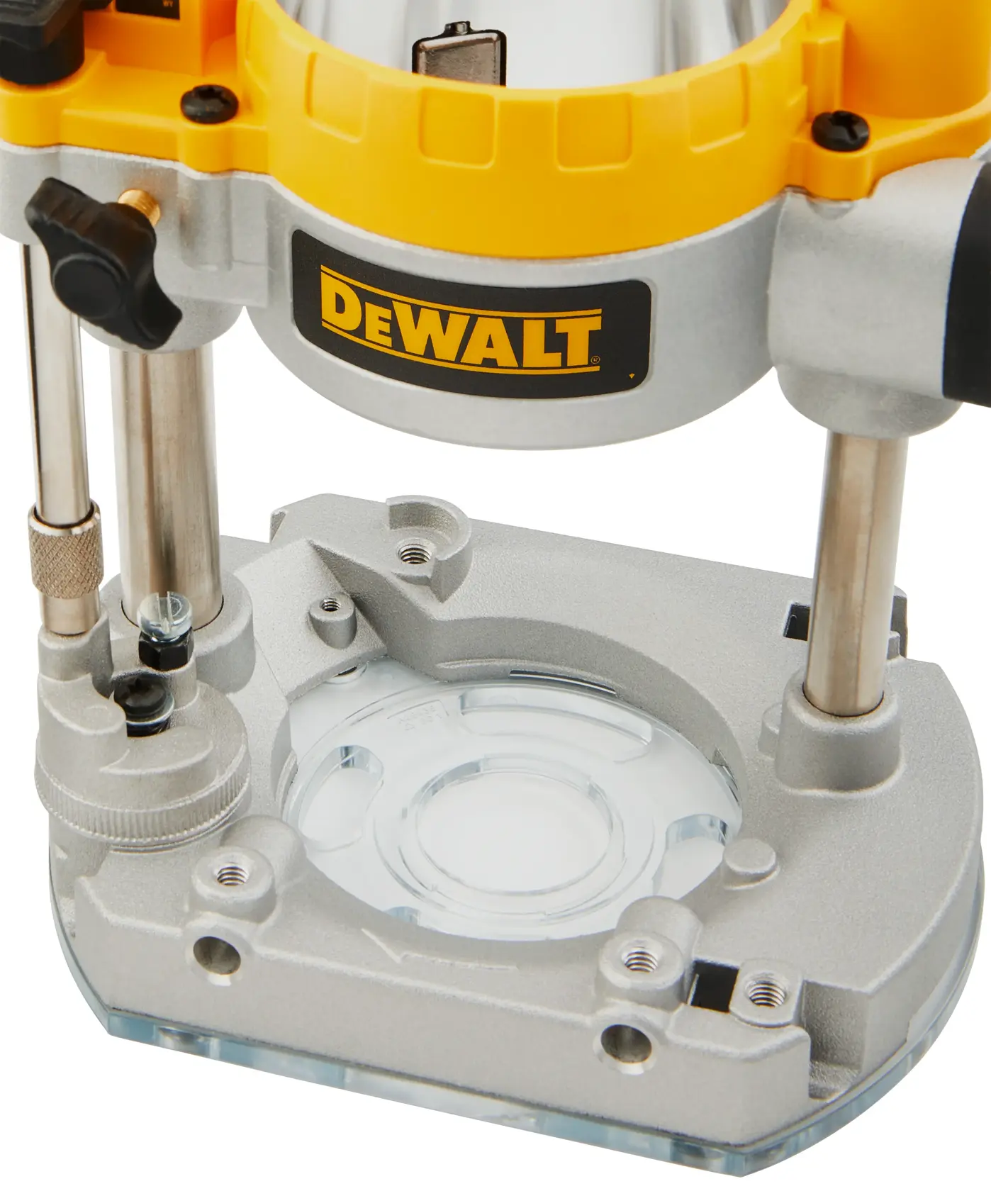 Close-up image of a DEWALT router base, showing the clear acrylic plate and metal components used for woodworking and precision routing.