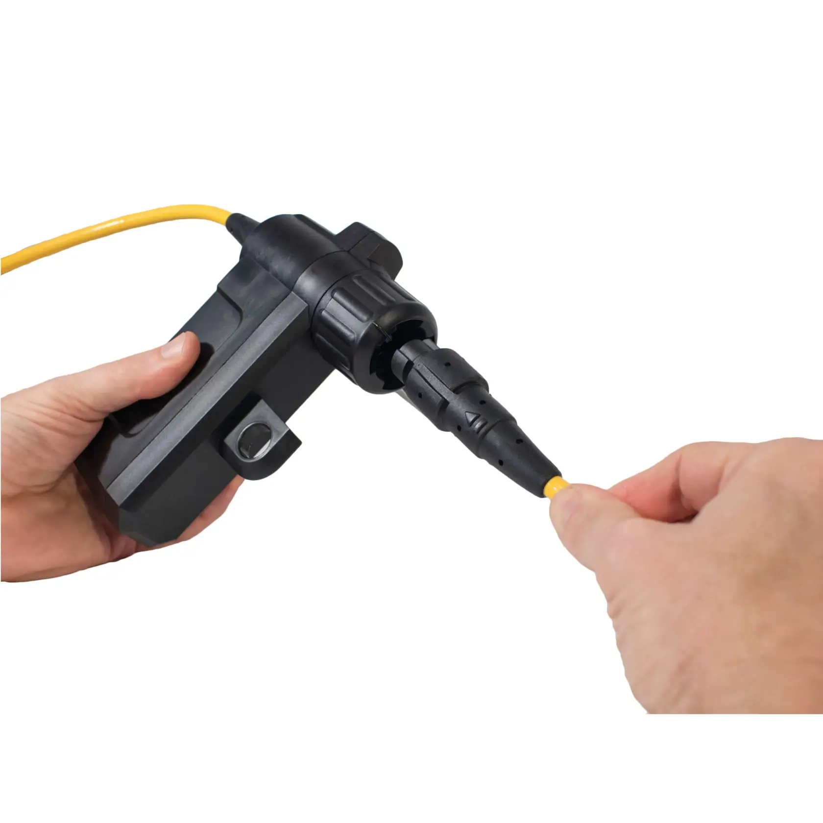 Close-up of two hands connecting a yellow cable to a black DEWALT device, possibly used for photography or electrical applications.