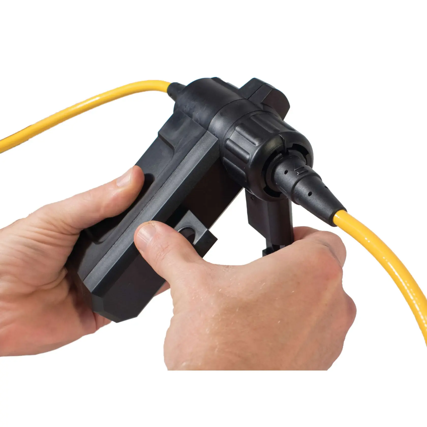 Close-up of hands holding and connecting a black DEWALT device with a yellow cable against a white background.