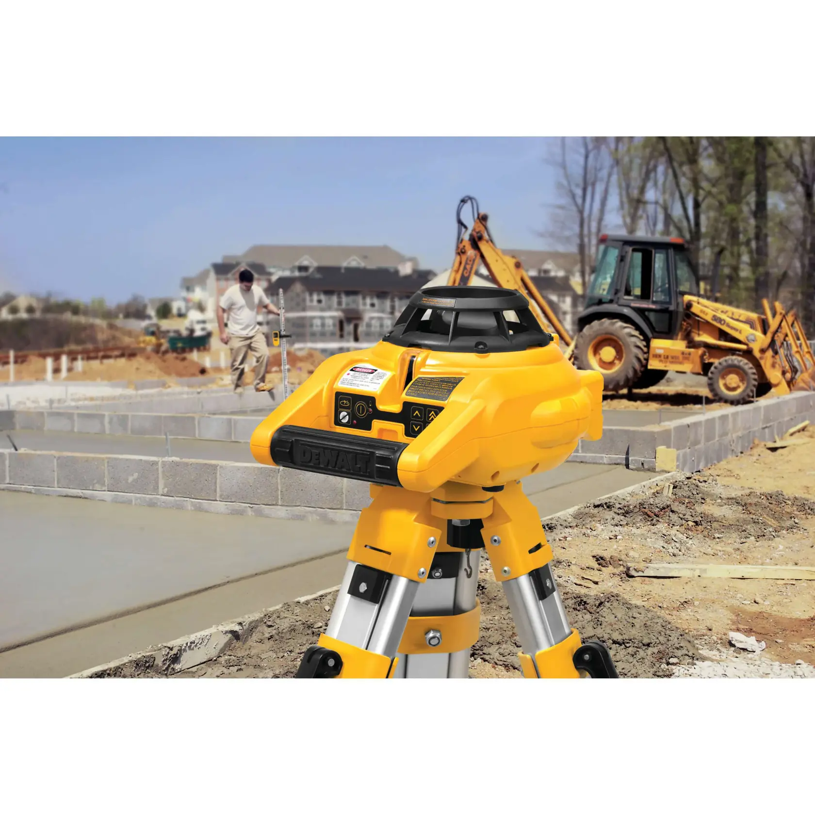 A DEWALT DW074KD rotary laser level mounted on a tripod at a construction site, with a worker and a backhoe visible in the background.