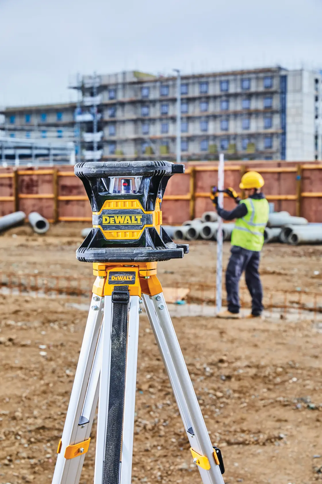 Image of a DEWALT DW080LRS rotary laser level. The laser has a rugged black and yellow design with rubberized handles. Key features highlighted in the image are: IP67 rating with 2 meter drop protection for jobsite durability, accuracy of 1/16 inch at 100 feet, 2000 foot range, dual axis slope mode, and Bluetooth compatibility with the DEWALT Tool Connect app.