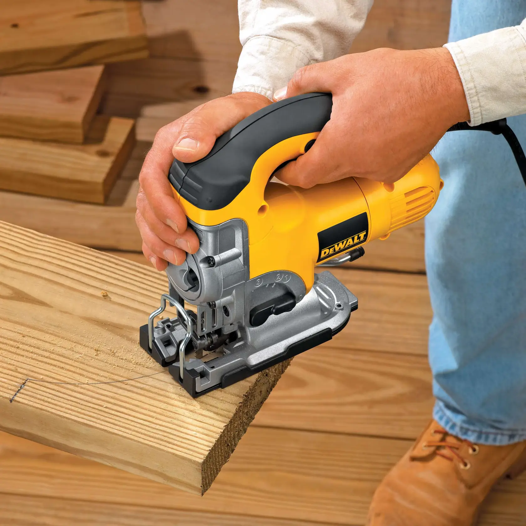 Person cutting wood with a yellow DEWALT jigsaw.