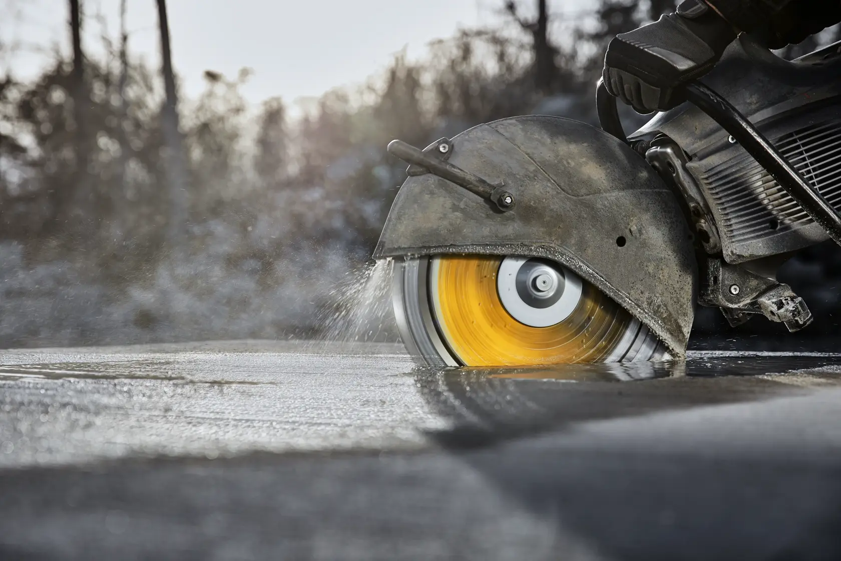 Close-up of a spinning DEWALT saw blade cutting wet concrete, promoting longer life with high diamond concentration.