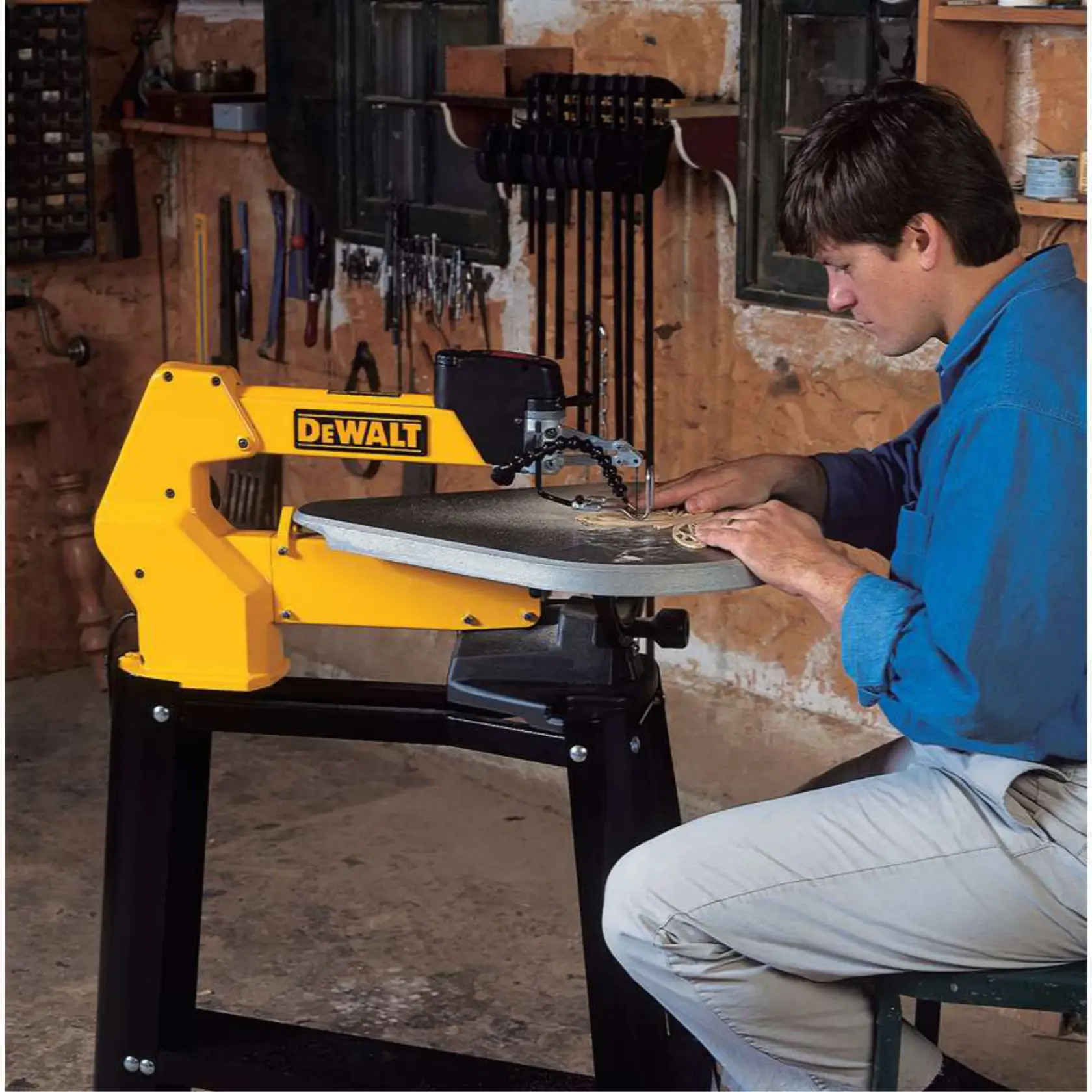 A person using a DEWALT scroll saw in a workshop, with various tools hanging on the wall in the background. The person's face is blurred for privacy.