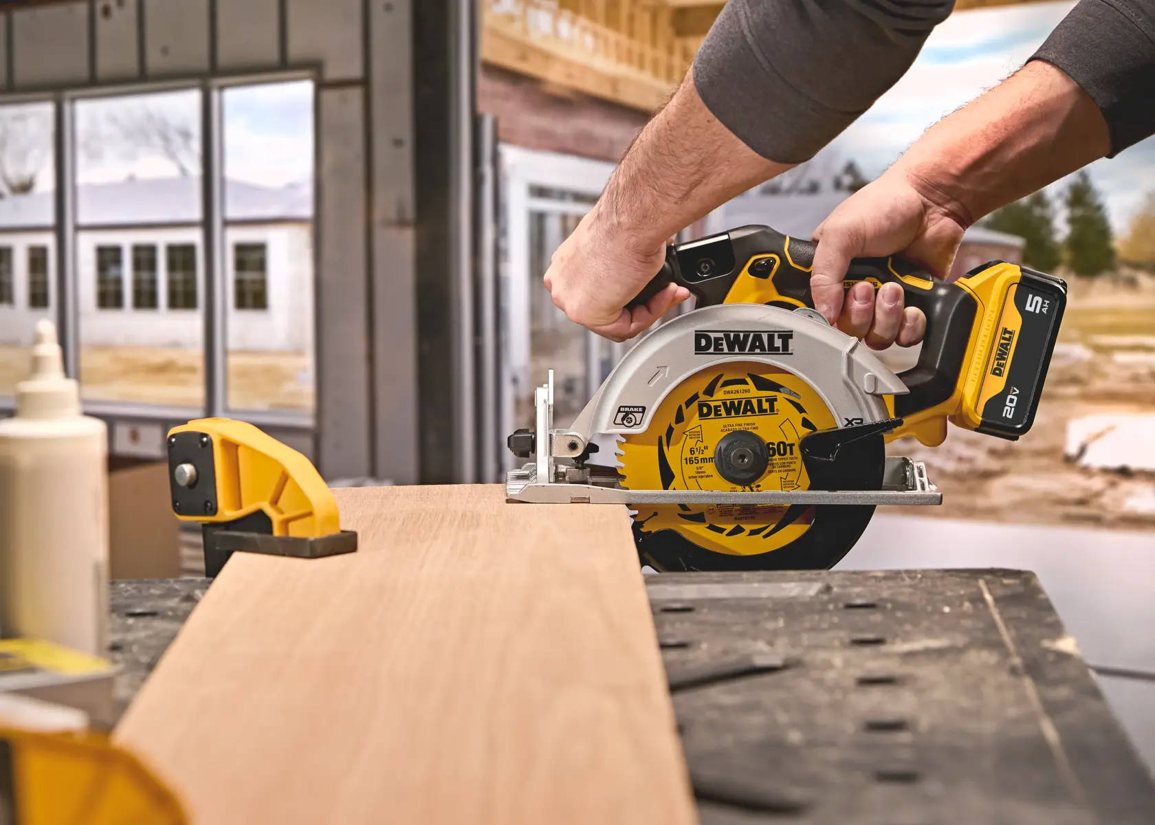 DEWALT circular saw cutting wood on a workbench in a construction setting.
