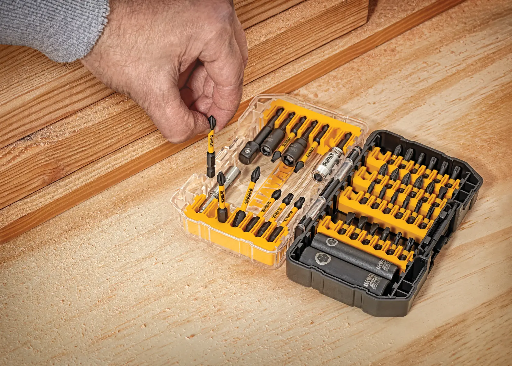 DEWALT ToughCase+ screwdriving set includes a transparent case with yellow accents, containing various screwdriver bits and accessories. Contents listed: 1 ToughCase+ container, 12 Phillips screwdriving bits, 8 square screwdriving bits, 4 slotted screwdriving bits, 9 Torx screwdriving bits, 1 magnetic bit tip holder, 1 magnetic screw lock sleeve, 1 socket adaptor, 2 sockets, and 2 nut drivers.