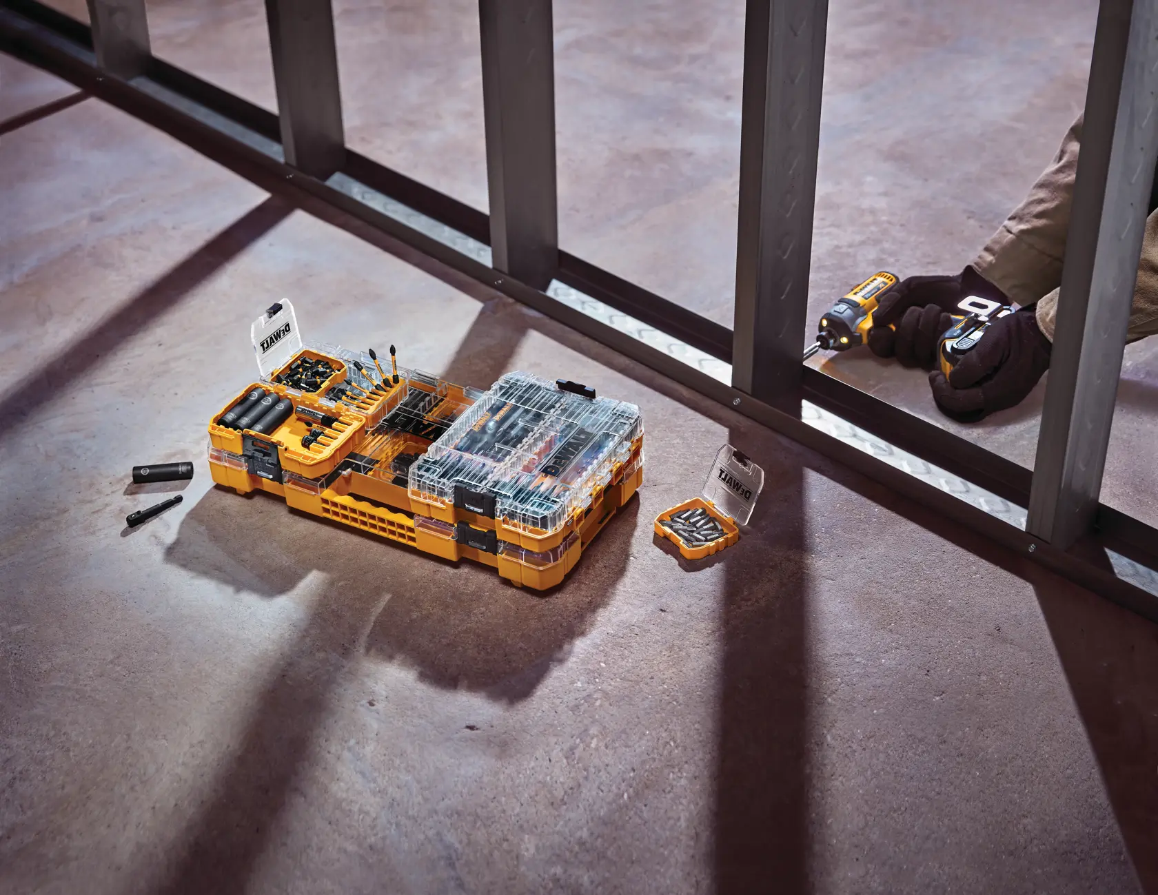 DEWALT DWA2NGFT40IR graphics showing an open ToughCase storage box containing various precision-machined FlexTorq bits and accessories organized in yellow trays, with labeled features including FlexTorq bits, precision-machined tips, and ToughCase+ storage.