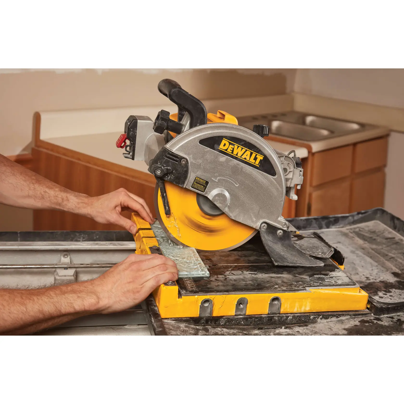 A person is using a DEWALT branded circular saw to cut a piece of tile on a worktable in a workshop or kitchen setting.
