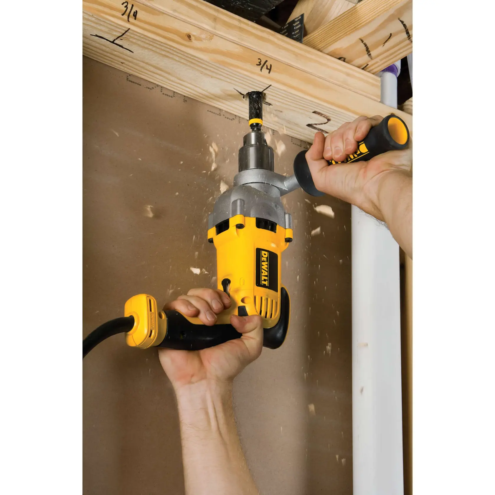 A person uses a DEWALT DWD210G power drill with a 360-degree locking side handle to drill into a wooden beam. The image highlights versatility and control of the tool in a construction or woodworking setting.
