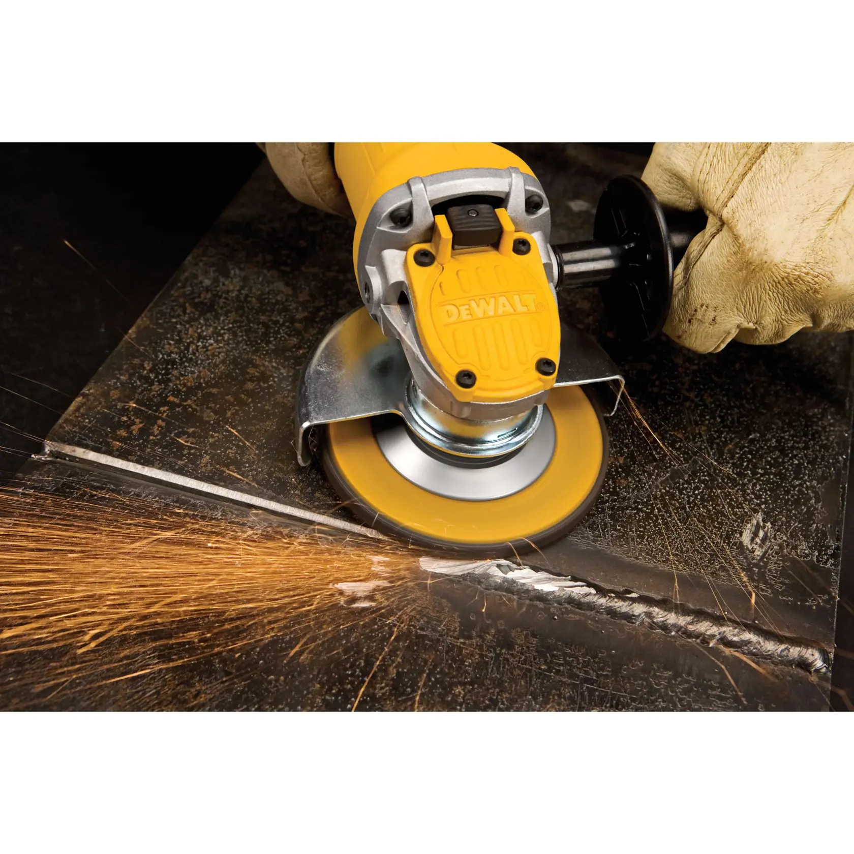 A close-up of a DEWALT DWE4120 angle grinder being adjusted by a person, showing the One-Touch guard feature over a metallic diamond plate surface.