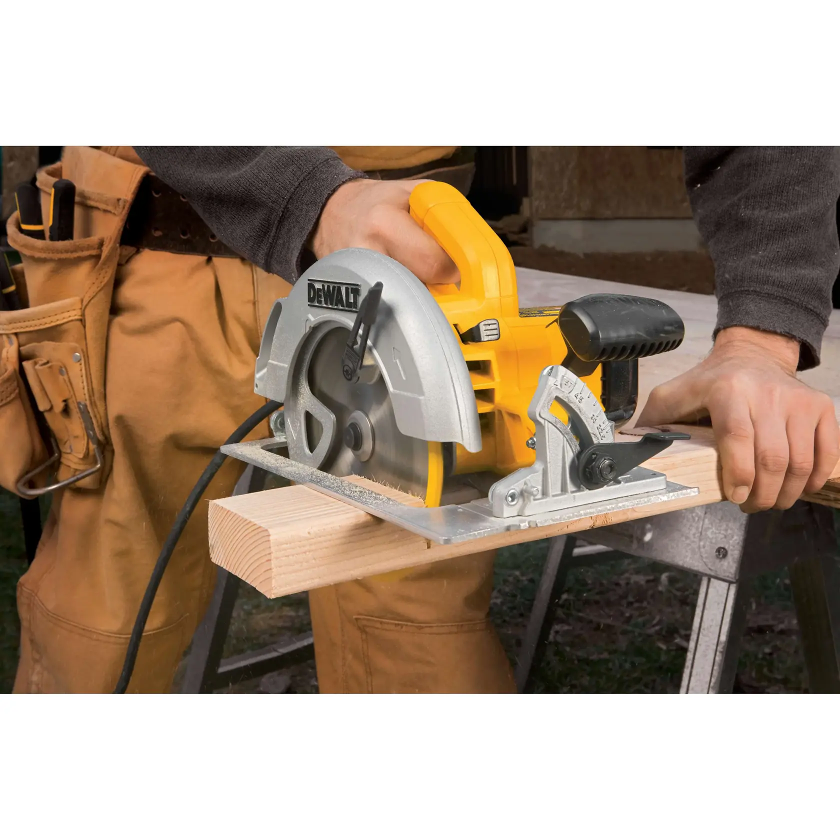 A person is using a DEWALT DWE575 circular saw to cut a piece of wood on a workbench. The saw is yellow and silver and is plugged in with a cord. The person is wearing work clothes.