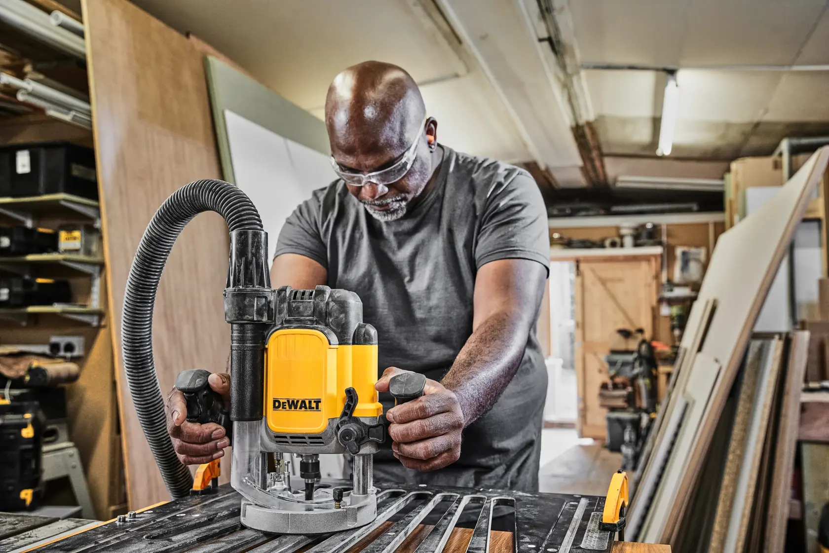 Person using DEWALT router DWE625-QS, DWE625 in workshop. Tool category: Photography. Multiple SKUs shown.