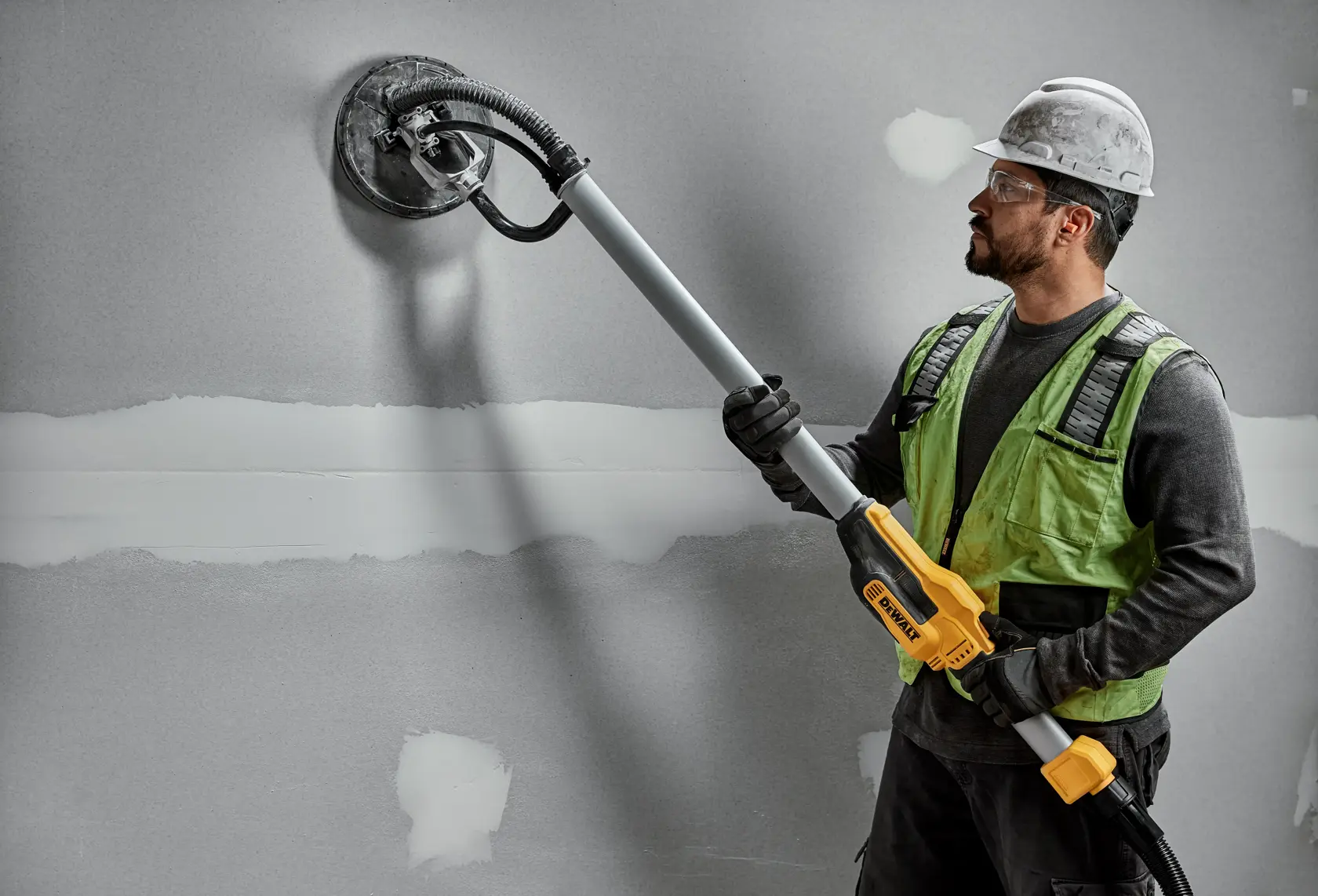 Worker uses DEWALT DWE7800, DWE7800-QS wall sander on drywall. Photography product shown in action.