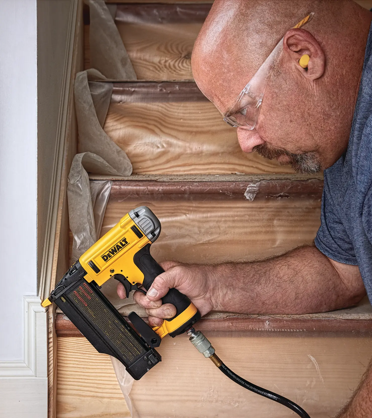 DEWALT DWFP2350K 23-gauge pin nailer. The image highlights three features: oil-free operation, tool-free jam release, and tool-free depth adjustment. The nailer is yellow and black with a DEWALT logo on the side.