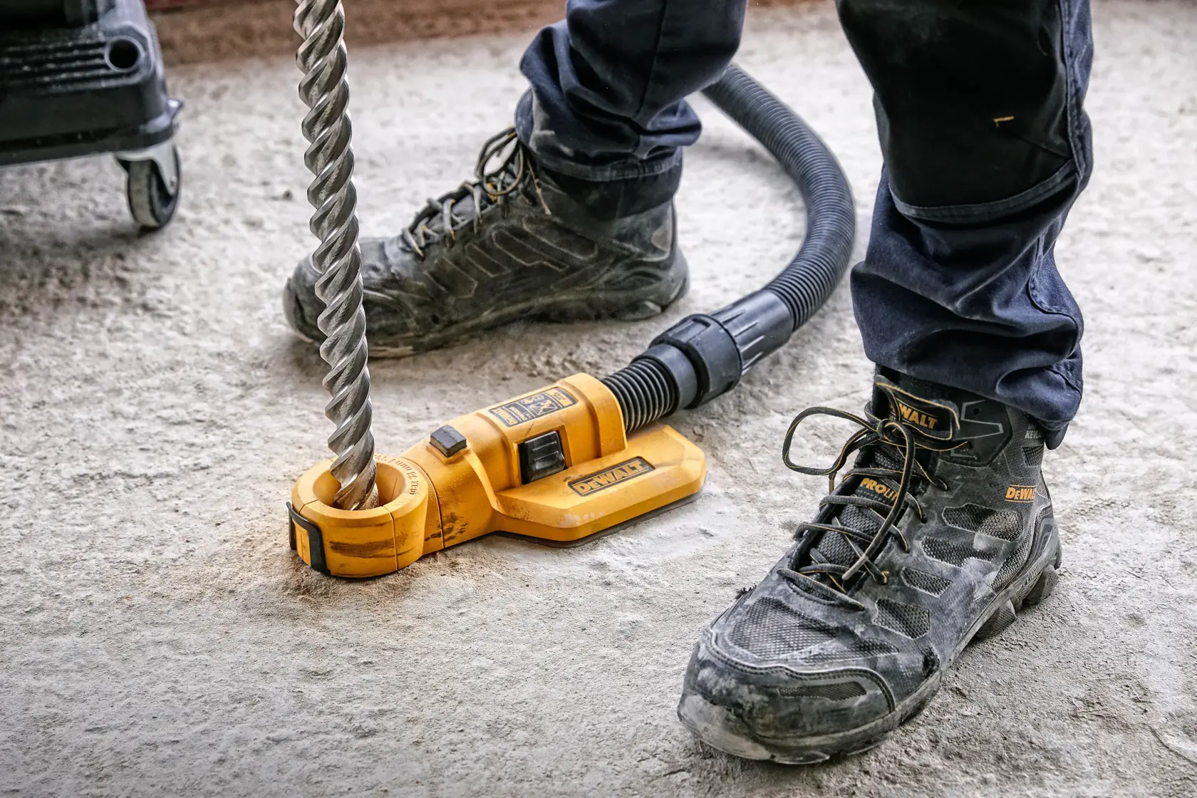 DEWALT tool for drilling, SKUs DWH050, DWH050K, DWH050-XJ, used on concrete floor by worker in boots.