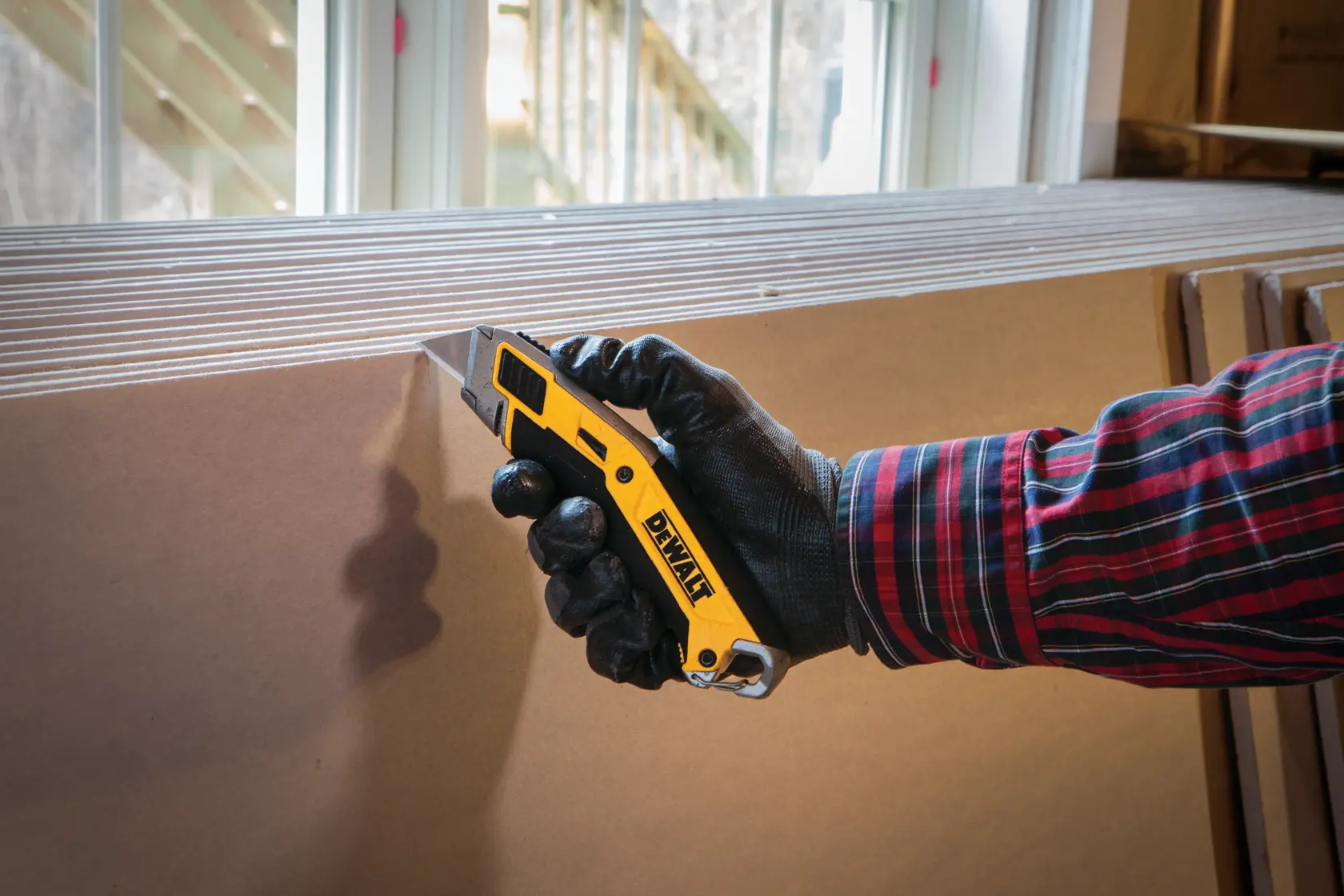Illustration showing blade change instructions for a DEWALT utility knife. A hand inserts a new blade into the tool, with an arrow indicating the direction to push. Text below reads: 'Insert new blade and push until it locks (lever does not need to be held down)'.