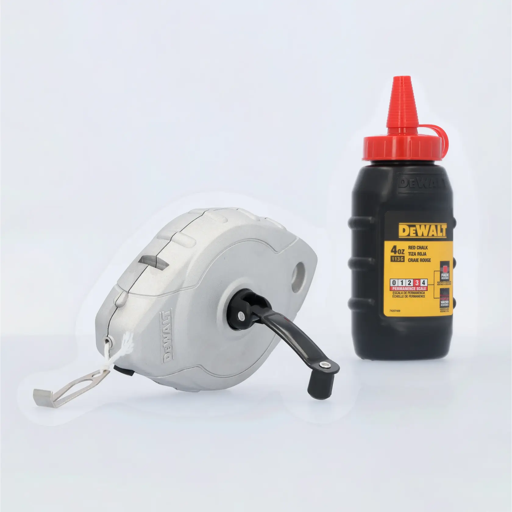 A DEWALT chalk line reel and a bottle of red chalk powder, used for marking straight lines in construction and carpentry projects. The reel is silver with a black winding handle, and the bottle is black with a red cap and yellow label.
