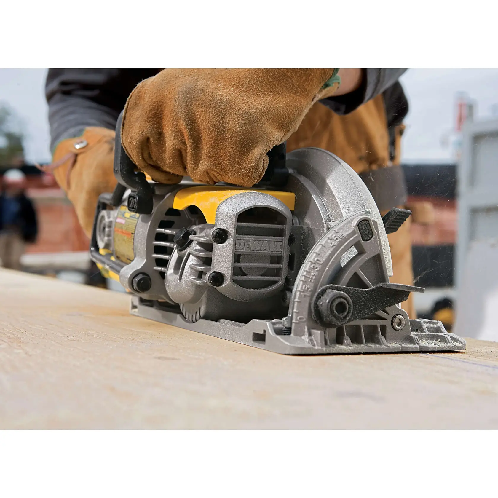A close-up of a DEWALT circular saw being operated outdoors by a person wearing protective work gloves, cutting wood.