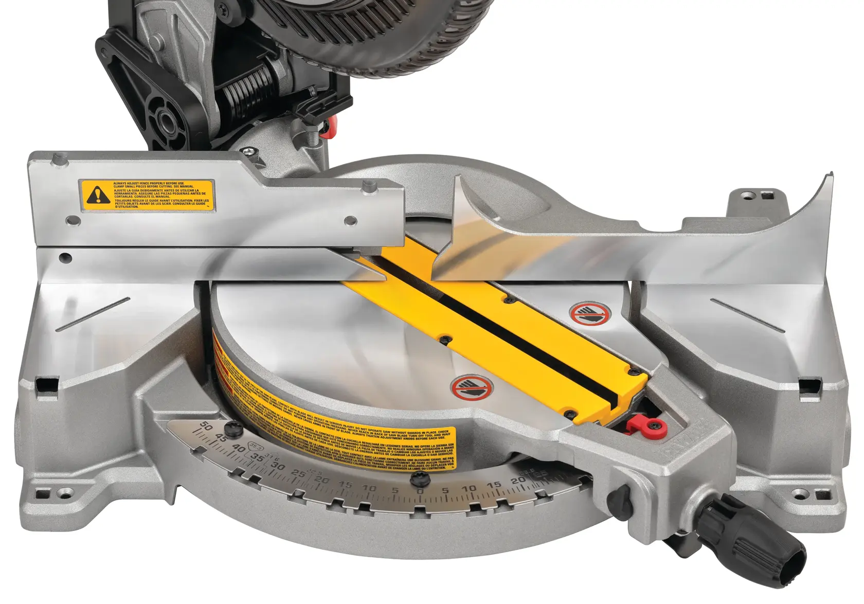 Close-up view of a DEWALT DWS713 miter saw base, showing the metal fence, yellow marked angles, and adjustment knob. The saw is positioned for precise woodworking cuts.