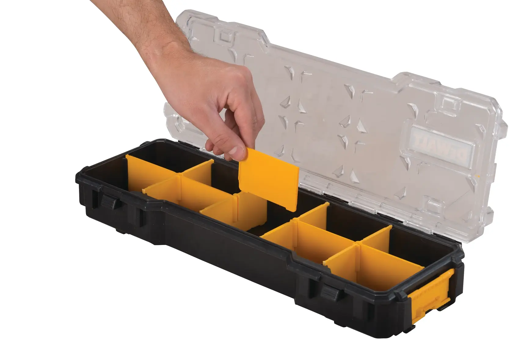 A hand is placing a yellow divider into a black DEWALT organizer box with a transparent lid. The box contains multiple yellow compartments for sorting small items.