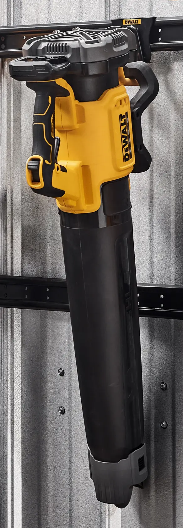 A DEWALT leaf blower with a yellow and black design is mounted vertically on a metal wall using a storage rack.