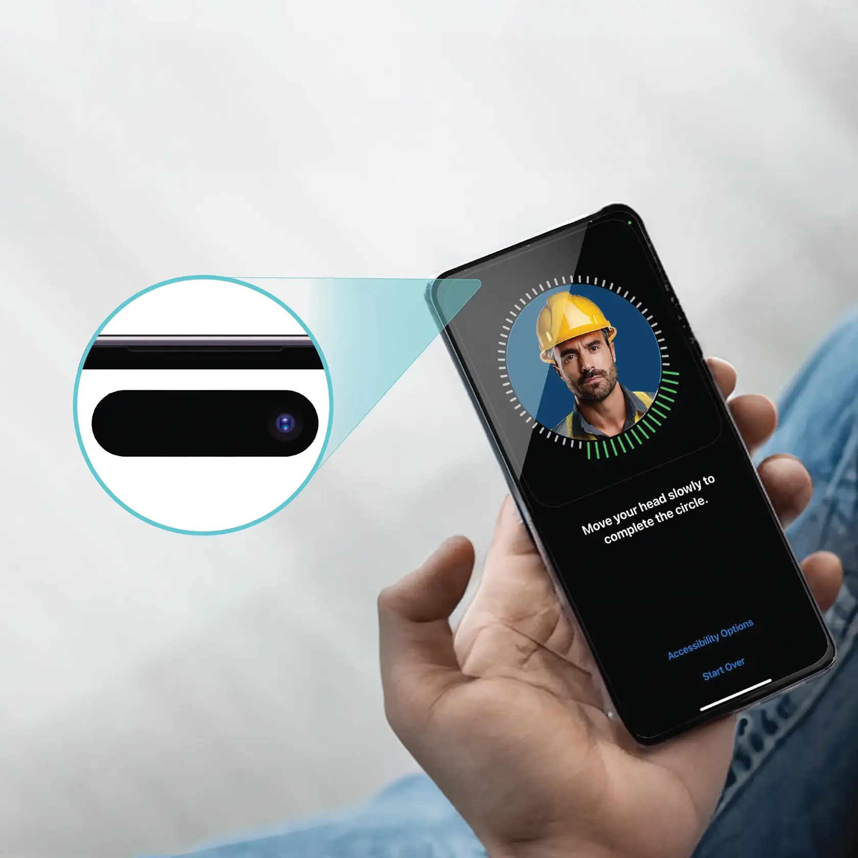 A person holds a smartphone displaying a facial recognition setup screen. The screen shows a circular animation around a blurred face and instructions to move the head slowly to complete the circle. An inset highlights the phone's front camera. The face on the phone screen is wearing a yellow safety helmet.