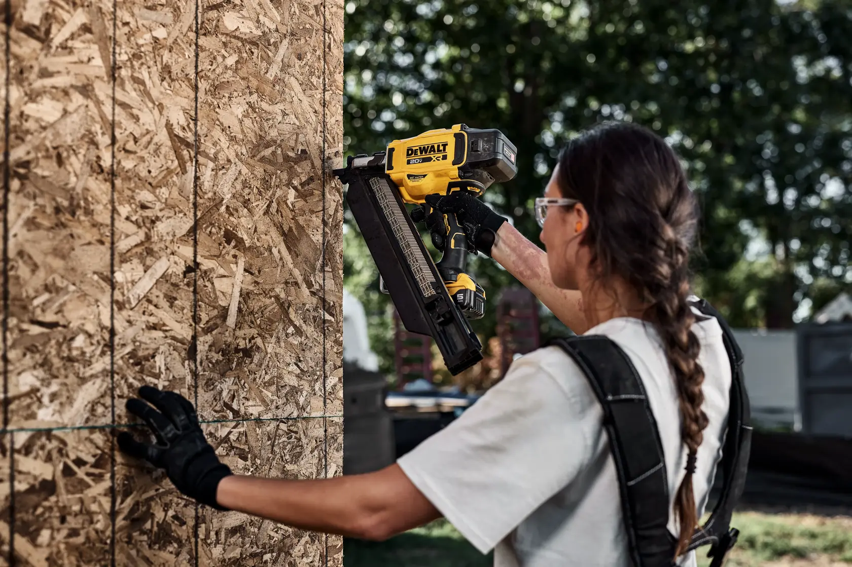 Person using DEWALT nailer DZN930-XJ, DZN930 on wood panel outdoors. Product category: Photography.